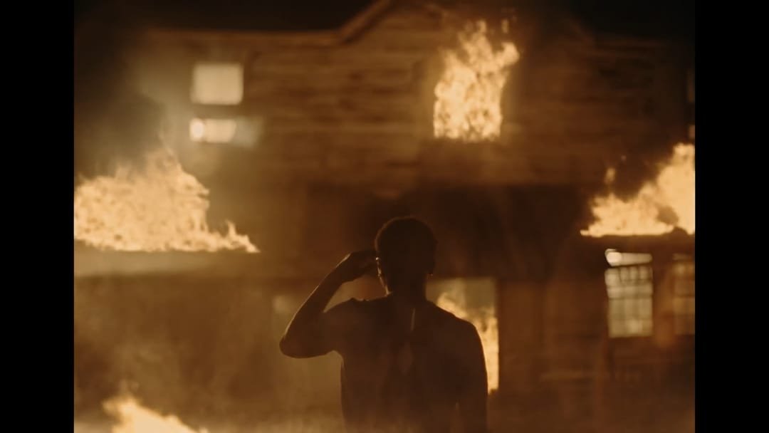 Silhouette in front of the burning house