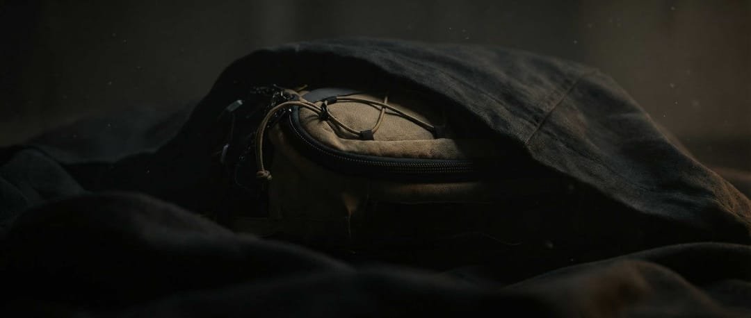 The bag under a dusty cloak, wide frame